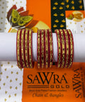 A set of red and gold chain bangles displayed on a white cylindrical stand, with a branded orange and white SAWRA GOLD box in the background.