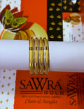 Four gold-plated chain bangles displayed on a white cylindrical stand, with SAWRA GOLD branding visible on the packaging behind them.