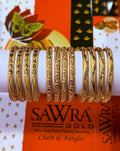 A set of ornate gold-plated bangles displayed on a white cylindrical stand, with SAWRA GOLD branding visible in the background.