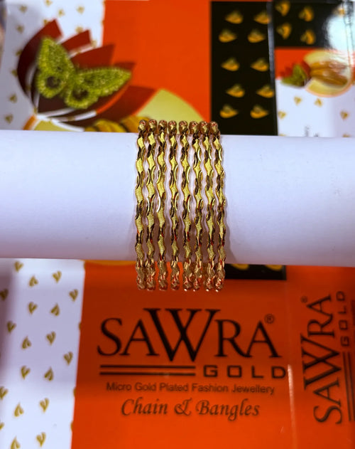 A stack of five gold chain bangles displayed on a white cylindrical stand, with an orange and white SAWRA GOLD brand box in the background.