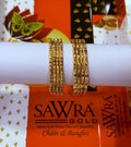 Two gold-plated chain bangles displayed on a white cylindrical stand, with SAWRA GOLD branding visible on the packaging in the background.