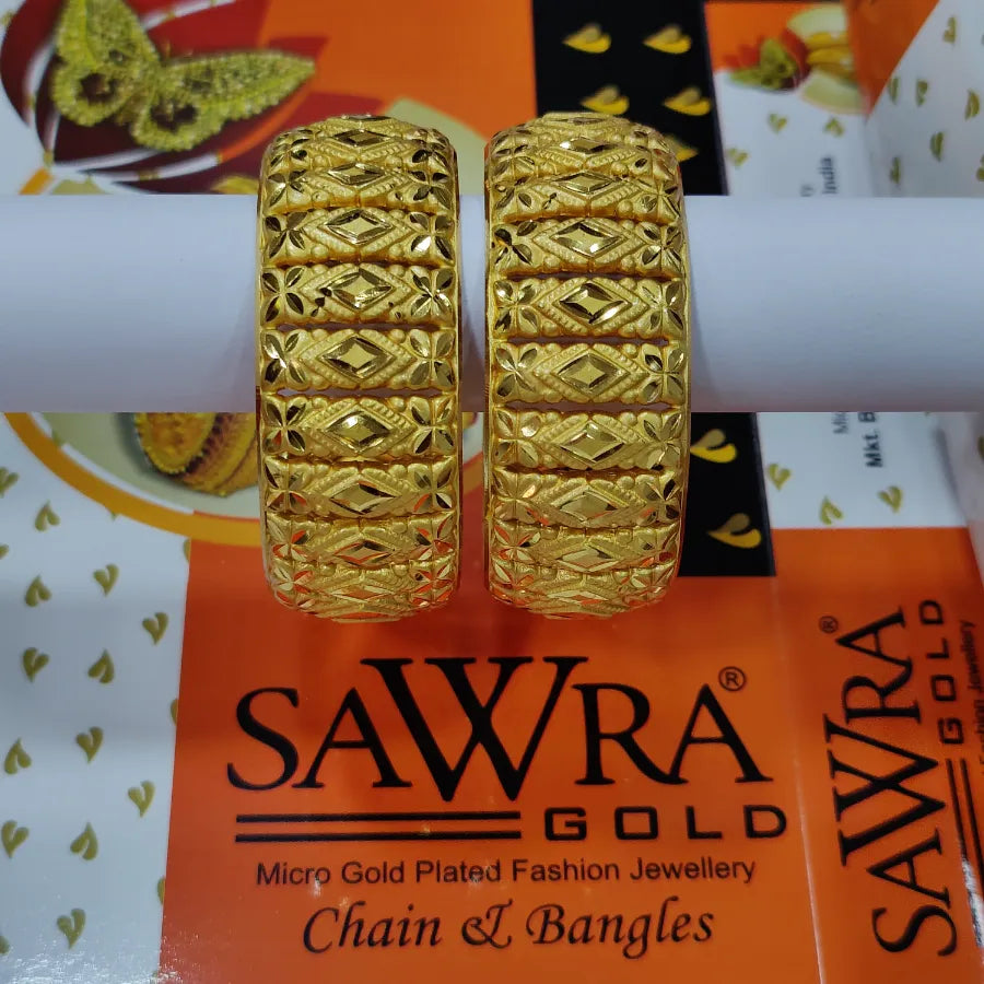 Gold bangles on a Sawra Gold branded stand with packaging in the background